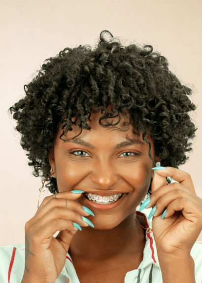 Smiling young woman with curly hair and metal braces